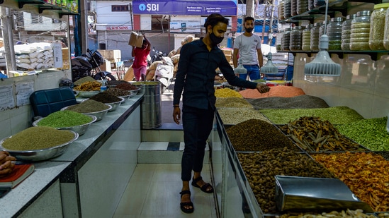 A man purchases essential items from a shop, at Khari Baowli in New Delhi, on May 25. CM’s announcement marks the beginning of the scaling down process of the ongoing lockdown imposed on April 19 to curb an unprecedented surge in Covid-19 cases. It has been extended at least five times so far, HT reported.(Vijay Verma / PTI)