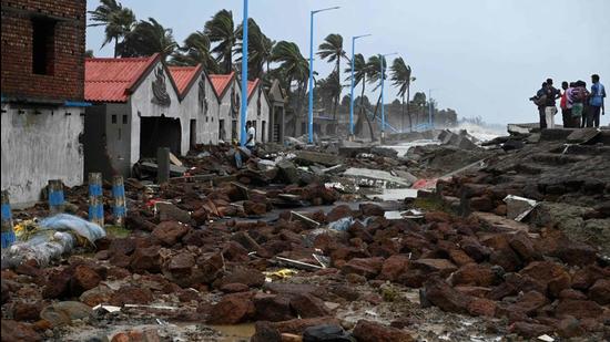 People walk through a damaged shoreline after Cyclone Yaas hit eastern coast in the Bay of Bengal, at a beach in Shankarpur, some 180 km from Kolkata on May 27. (AFP)