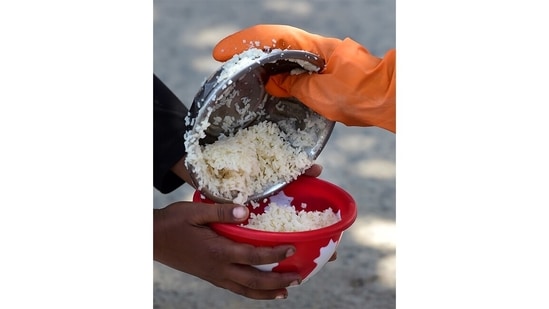 Food being served during a community feeding session amid the Covid-induced lockdown, in New Delhi, on May 24. Under the ongoing lockdown regulations, there is a complete ban on all economic activities, with exceptions for people, institutes and enterprises engaged in delivery of essential goods and services.(Kamal Kishore / PTI)
