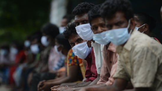 TOPSHOT - People wait to receive a meal distributed by an humanitarian organisation during a complete lockdown imposed by the the state government as a preventive measure against the spread of the Covid-19 coronavirus in Chennai on May 25, 2021. (AFP)
