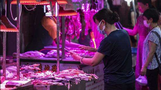 A customer uses a mobile phone to make a digital payment at an open-air market in Guangzhou, China, on Monday. (Bloomberg) A customer uses a mobile phone to make a digital payment at an open-air market in Guangzhou, China, on Monday. (Bloomberg)