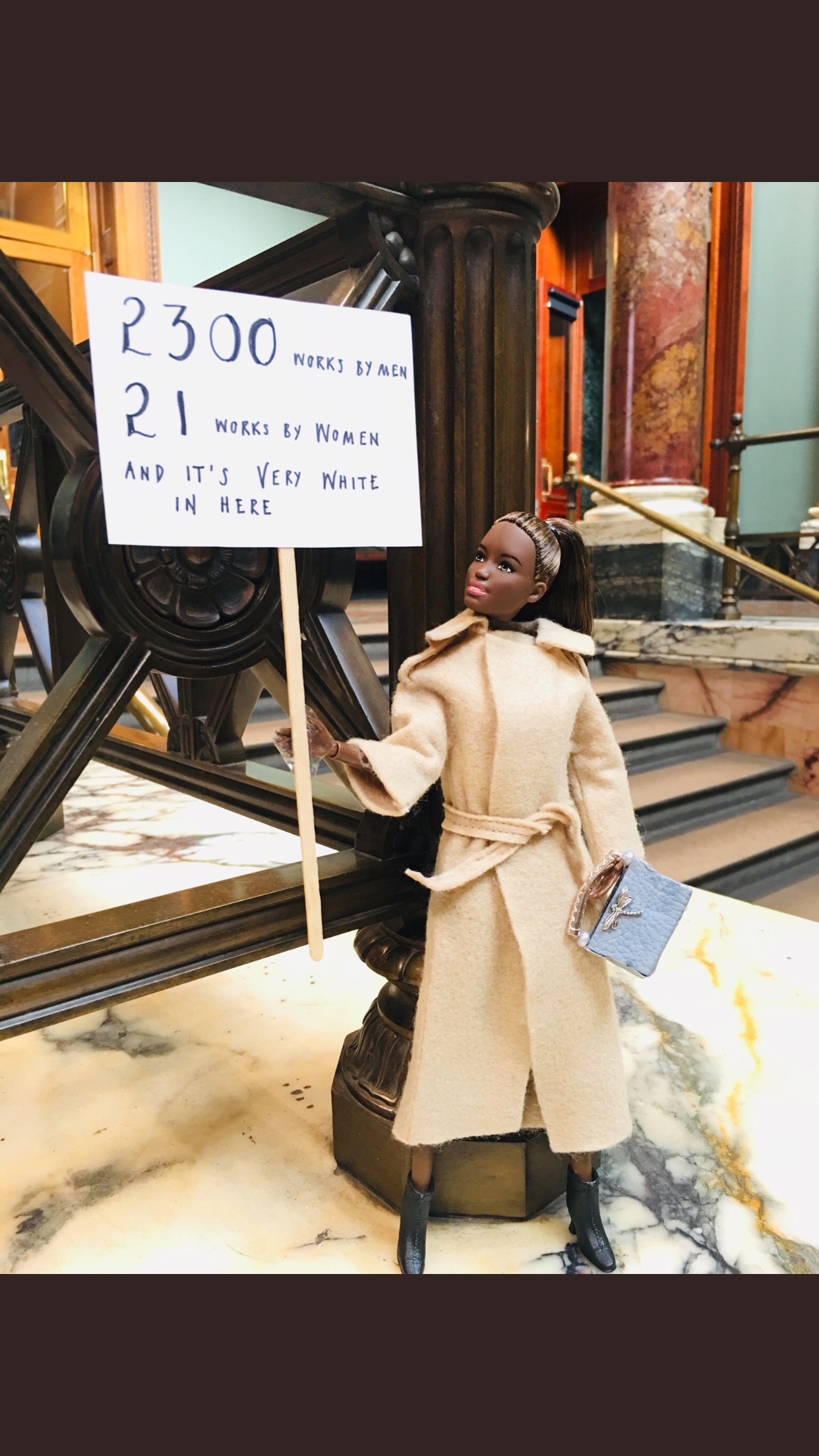 A Black AAB holds up a placard pointing out that it’s far too White at the National Gallery, London, besides which the permanent collection features 2,300 works by men, and just 21 by women. A Black AAB holds up a placard pointing out that it’s far too White at the National Gallery, London, besides which the permanent collection features 2,300 works by men, and just 21 by women.