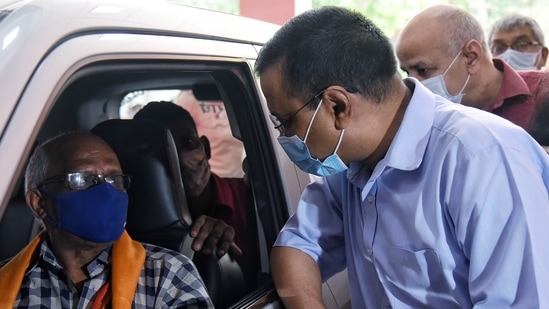 Delhi Chief Minister Arvind Kejriwal and Delhi Deputy CM Manish Sisodia interact with people during a drive-in vaccination at Chhatrasal Stadium in New Delhi. Delhi Chief Minister Arvind Kejriwal and Delhi Deputy CM Manish Sisodia interact with people during a drive-in vaccination at Chhatrasal Stadium in New Delhi.