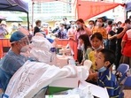 A medical worker collects a swab from a resident during a mass testing for the coronavirus disease (Covid-19) at a makeshift testing site at a stadium in Guangzhou, China.