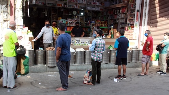 People stand in a queue for buying essential commodities at the market during the lockdown, in Gurugram. (ANI Photo) People stand in a queue for buying essential commodities at the market during the lockdown, in Gurugram. (ANI Photo)