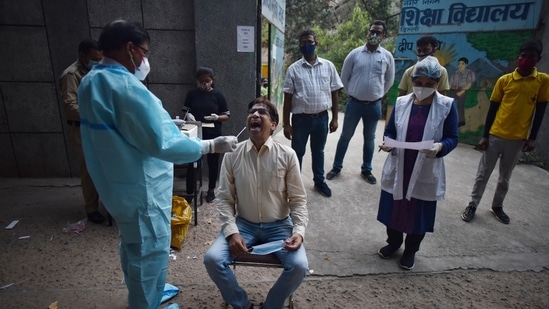 A health worker collects a swab sample for Covid-19 test.(Sanchit Khanna/HT PHOTO) A health worker collects a swab sample for Covid-19 test.(Sanchit Khanna/HT PHOTO)