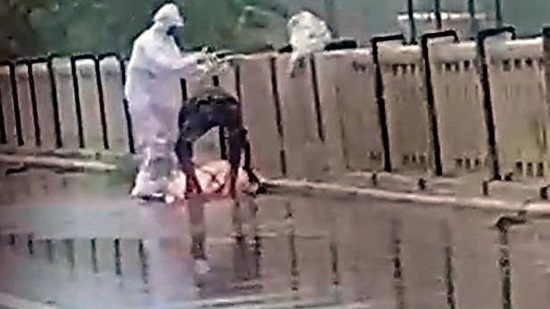 A video grab of the two men throwing a Covid patient’s body from the parapet of a bridge into Rapti river in UP’s Balrampur. (HT Photo) A video grab of the two men throwing a Covid patient’s body from the parapet of a bridge into Rapti river in UP’s Balrampur. (HT Photo)