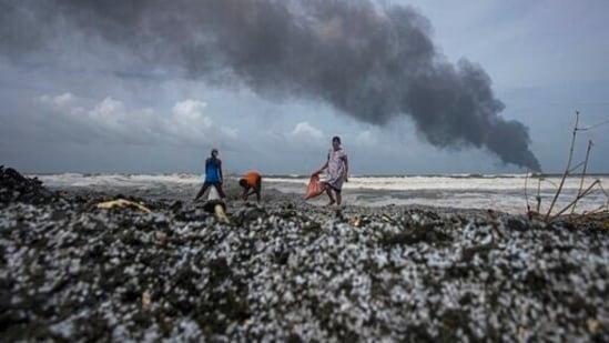 Impoverished Sri Lankans salvage wreckage washed off to the shore from the burning Singaporean ship MV X-Press Pearl which is anchored off Colombo port at Kapungoda, outskirts of Colombo, Sri Lanka.(AP)