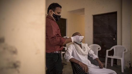A health worker takes a swab sample at a Covid-19 testing site set up at the Panchayat house of a village in the Gautam Budh Nagar district of Noida on May 30. India also began the week reporting the lowest daily new coronavirus infections in 50 days with 1,52,734 cases logged for the previous 24 hours according to Union Health Ministry data updated on May 31.(Anindito Mukherjee / Bloomberg)