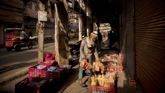 A street vendor arranges bread outside stores during lockdown restrictions in New Delhi on May 31. While shops have been permitted to open for longer hours, at some places malls have also been allowed to function on certain conditions. However, education institutions will continue to remain closed, PTI reported.(Anindito Mukherjee / Bloomberg)