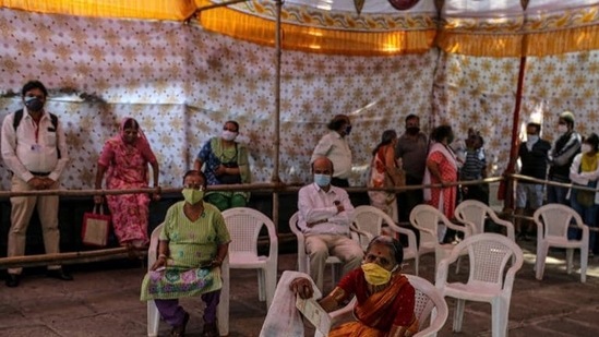 People wait at a Covid-19 vaccination center set up at a municipal hospital in Pune, Maharashtra, India (BLOOMBERG)