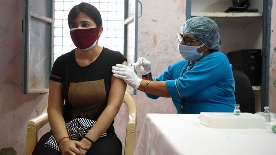 A health worker inoculating a person with a Covid-19 vaccine at Dundshera Village in Gurugram on May 30. A total of 21,31,54,129 doses have been administered through 30,28,295 sessions, according to the provisional report till 7 am on May 31.(Parveen Kumar / HT Photo)
