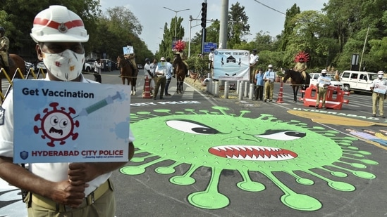 A police personnel with a placard next to a cartoon depiction of the coronavirus on a road to create public awareness against the Covid-19, in Hyderabad on May 29. A total of 3,29,100 deaths from the disease have been reported so far in the country with 3,128 of these added yesterday. The Health Ministry stressed that more than 70% of the deaths occurred due to comorbidities.(PTI)