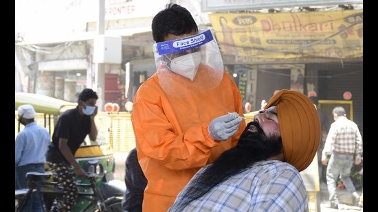 A health worker collecting swab sample during a Covid testing camp held by the health department at Chaura Bazar in Ludhiana on Monday. (Harsimar Pal Singh/HT) A health worker collecting swab sample during a Covid testing camp held by the health department at Chaura Bazar in Ludhiana on Monday. (Harsimar Pal Singh/HT)