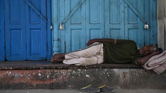 A man sleeps outside a closed shop during a lockdown imposed as preventive measure against the spread of the Covid-19 coronavirus, in the old quarters of New Delhi on May 23, 2021. (AFP) A man sleeps outside a closed shop during a lockdown imposed as preventive measure against the spread of the Covid-19 coronavirus, in the old quarters of New Delhi on May 23, 2021. (AFP)