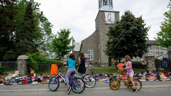 Prime minister Justin Trudeau said he will be talking to his ministers about further things his government needs to do to support survivors and the community. In picture - Local children of Kahnawake, Quebec stop to view the hundreds of shoes placed in front of the St. Francis Xavier Church.(AFP)