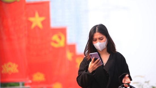 A woman wearing face mask looks at her phone in Hanoi, Vietnam. Vietnam says it has discovered a new coronavirus variant that’s a hybrid of strains first found in India and the UK. (AP) A woman wearing face mask looks at her phone in Hanoi, Vietnam. Vietnam says it has discovered a new coronavirus variant that’s a hybrid of strains first found in India and the UK. (AP)