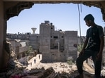 Mahmoud Al-Masri, 14, stands for a portrait in his bedroom that was damaged when an airstrike destroyed the neighboring building prior to a cease-fire that halted an 11-day war between Hamas and Israel, on May 26 in Beit Hanoun, Gaza Strip.(John Minchillo / AP)