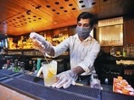 A bartender making drinks for customers on the first day of the reopening of liquor serving bars, at Hauz Khas Village in New Delhi after the reduction in Covid 19 cases following first wave. 