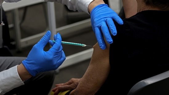 A healthcare worker administers a dose of Covid-19 vaccine to a beneficiary.(Bloomberg)