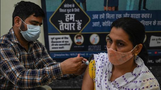 A health worker inoculates a woman with a dose of the Covishield vaccine at a civil hospital in Jind in Haryana. (AFP)
