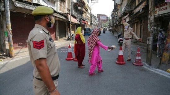 Policemen direct pedestrians towards a Covid-19 testing booth at a market during a lockdown to curb the spread of coronavirus in Jammu, India, Monday, May 31, 2021. (Channi Anand / AP)