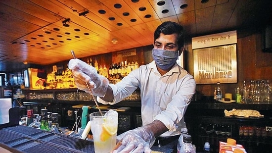 A bartender making drinks for customers on the first day of the reopening of liquor serving bars, at Hauz Khas Village in New Delhi after the reduction in Covid 19 cases following first wave. ( Amal KS / Hindustan Times) A bartender making drinks for customers on the first day of the reopening of liquor serving bars, at Hauz Khas Village in New Delhi after the reduction in Covid 19 cases following first wave. ( Amal KS / Hindustan Times)