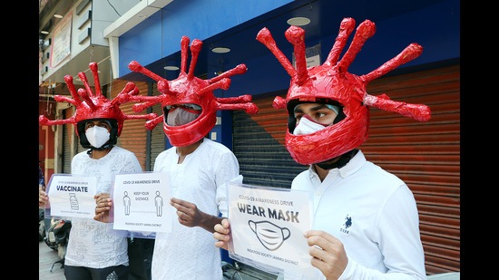 Red Cross supporters wearing special helmets spread Covid-19 awareness during a campaign in Jammu on Wednesday. (ANI) Red Cross supporters wearing special helmets spread Covid-19 awareness during a campaign in Jammu on Wednesday. (ANI)