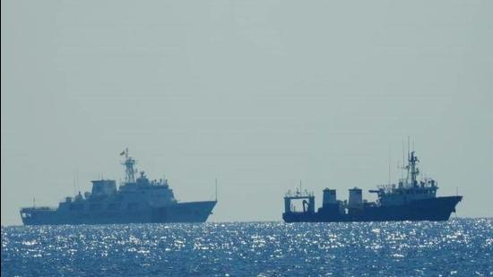 A Chinese Coast Guard patrol ship (left) is seen near an unidentified vessel at South China Sea. (REUTERS)