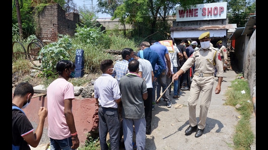 People stand in a queue to buy liquor at a shop in Jammu on Wednesday. (ANI) People stand in a queue to buy liquor at a shop in Jammu on Wednesday. (ANI)