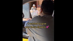 The image shows the social media influencer giving flowers to an elderly man.