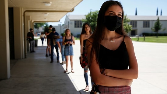 Zoe Isabella Rosales, 18, stands in line outside the Marysville High School gymnasium before receiving her graduation cap and gown in Marysville, California on May 25. "It's made me more grateful and more self-aware of my privileges," Rosales said. "But it's also made me really angry ... seeing other people who have had their whole world changed and their ability to learn completely blocked."(Brittany Hosea-Small / REUTERS)