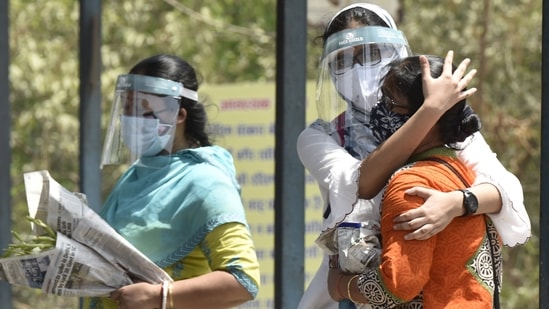 Relatives mourn death of a loved one at a crematorium in Delhi. (HT Photos)