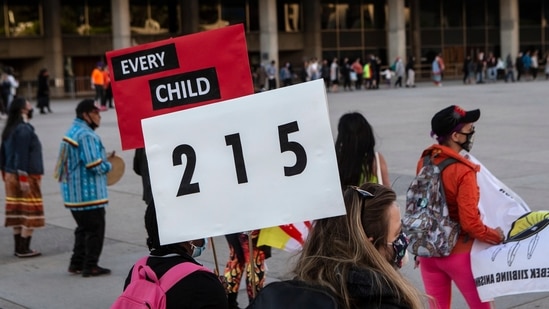 People form a circle during a vigil in Toronto on Sunday May 30, 2021, for the 215 Indigenous children, whose remains were uncovered on the grounds of a former residential school near Kamloops, British Columbia. (AP) People form a circle during a vigil in Toronto on Sunday May 30, 2021, for the 215 Indigenous children, whose remains were uncovered on the grounds of a former residential school near Kamloops, British Columbia. (AP)