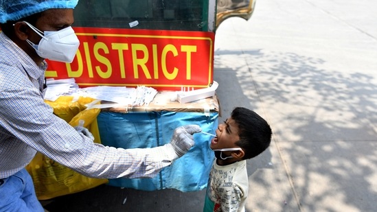 A health care worker collects a swab sample of a child to conduct the test for Covid-19 at ISBT Kashmere Gate, amid the surge in cases, in New Delhi on Friday. (ANI Photo) A health care worker collects a swab sample of a child to conduct the test for Covid-19 at ISBT Kashmere Gate, amid the surge in cases, in New Delhi on Friday. (ANI Photo)