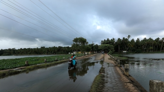 A motorist seen crossing a waterlogged stretch during overcast weather caused by the onset of the monsoon, at Vellayani Lake, in Thiruvananthapuram district, on June 3. IMD said the westerly winds have strengthened in the lower levels with speeds up to 20 knots. (Vivek R Nair / HT Photo) A motorist seen crossing a waterlogged stretch during overcast weather caused by the onset of the monsoon, at Vellayani Lake, in Thiruvananthapuram district, on June 3. IMD said the westerly winds have strengthened in the lower levels with speeds up to 20 knots. (Vivek R Nair / HT Photo)