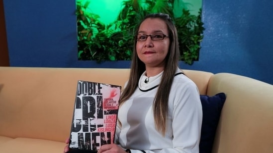 Linda Lopez holds her book "Double Crime" which she signs with her middle name Loaiza in Caracas, Venezuela. (Reuters)
