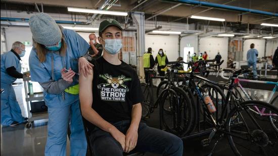 A cyclist receives a dose of the Pfizer-BioNTech vaccine at the Gilles Villeneuve racetrack in Montreal, Quebec, Canada. (Bloomberg) A cyclist receives a dose of the Pfizer-BioNTech vaccine at the Gilles Villeneuve racetrack in Montreal, Quebec, Canada. (Bloomberg)