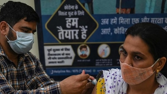 A health worker inoculates a woman with a dose of the Covishield vaccine at a civil hospital in Jind in Haryana. (AFP)