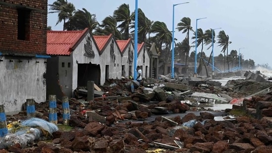 People walk through a damaged shoreline after Cyclone Yaas hit India's eastern coast in the Bay of Bengal, at a beach in Shankarpur, some 180 km from Kolkata on May 27. People walk through a damaged shoreline after Cyclone Yaas hit India's eastern coast in the Bay of Bengal, at a beach in Shankarpur, some 180 km from Kolkata on May 27.