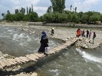 Health workers crossing a wooden bridge during door-to-door Covid-19 vaccinations at Tral village, south of Srinagar on June 5. India reported 1,14,460 new Covid-19 cases, 1,89,232 discharges, and 2,677 deaths in the last 24 hours, the Union Health Ministry informed in its health update on June 6.