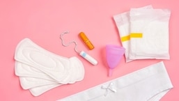 Uma variedade de produtos menstruais exibidos, de absorventes higiênicos a tampões e opções mais sustentáveis, como o coletor menstrual.