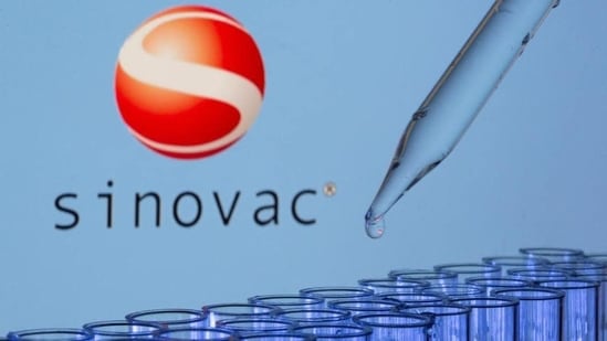 Test tubes are seen in front of a displayed Sinovac logo in an illustration. (REUTERS/FILE)