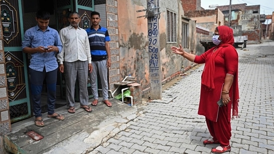 An Accredited Social Health Activist (ASHA) worker (R) speaks to a family during a door-to-door Covid-19 vaccine awareness campaign in Kalwa village on the outskirts of Jind on June 1. The national recovery rate from illness due to Covd-19 has as on June 6 increased to 93.67%. The weekly positivity rate, meanwhile, stands at 6.54%. (Money Sharma / AFP)