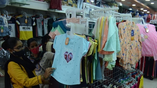 People buy clothes at garment store as all essential and non-essential shops open from 7am to 2pm at Station Road Market in Thane (HT file photo)
