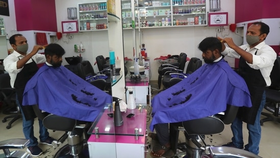 A man getting a haircut is reflected in a mirror at a barber shop in Mumbai on June 7. The Maharashtra government has announced its five-level plan to relax the coronavirus-induced restrictions in the state, based on the weekly positivity rate and the occupancy of oxygen beds. (Rafiq Maqbool / AP) A man getting a haircut is reflected in a mirror at a barber shop in Mumbai on June 7. The Maharashtra government has announced its five-level plan to relax the coronavirus-induced restrictions in the state, based on the weekly positivity rate and the occupancy of oxygen beds. (Rafiq Maqbool / AP)