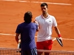 Italy's Lorenzo Musetti shakes hands with Serbia's Novak Djokovic after retiring injured from their fourth-round match.