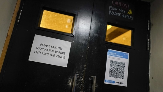 A sign attached on the entry door to the Moth Club in Hackney asks patrons to sanitize hands upon entry in London on May 30.(Alberto Pezzali / AP)