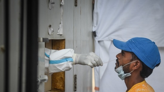 A health worker collects swab samples for Covid test, at a Government Hospital, in Karol Bagh, in New Delhi, India (Photo by Sanchit Khanna/ Hindustan Times)