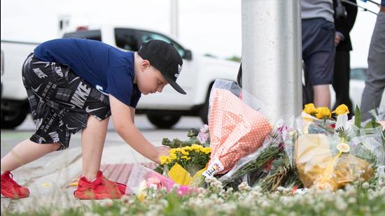 A young Londoner leaves a Hulk Action Figure for the nine year old boy who remains in hospital with serious injuries, at the scene where a man driving a pickup truck struck and killed four members of a Muslim family in London, Ontario, Canada on June 7, 2021.(AFP Photo)